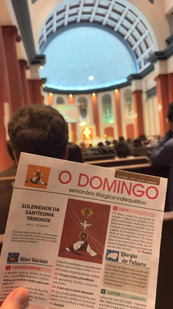 Folheto de missa na mão dentro de uma igreja de cúpula azul