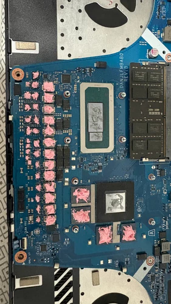 Placa-mãe de notebook desmontado, com processador e pads térmicos rosa