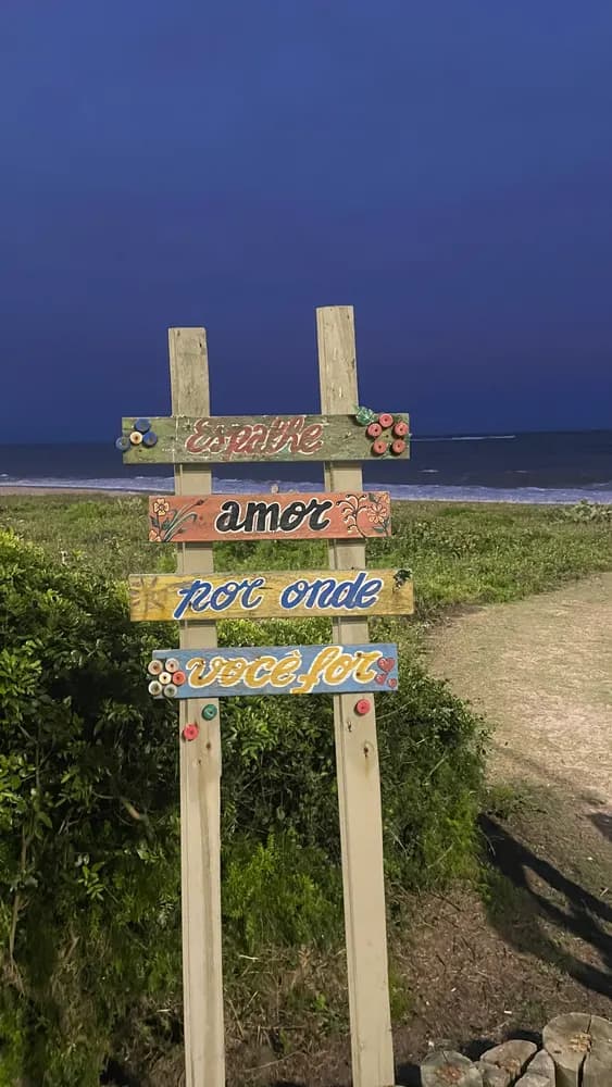 Placas pintadas à mão com a frase Espalhe amor por onde você for, ao anoitecer