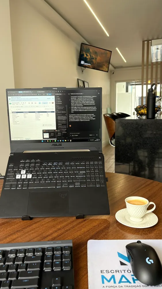 Notebook aberto com planilha na tela e xícara de café em mesa de madeira
