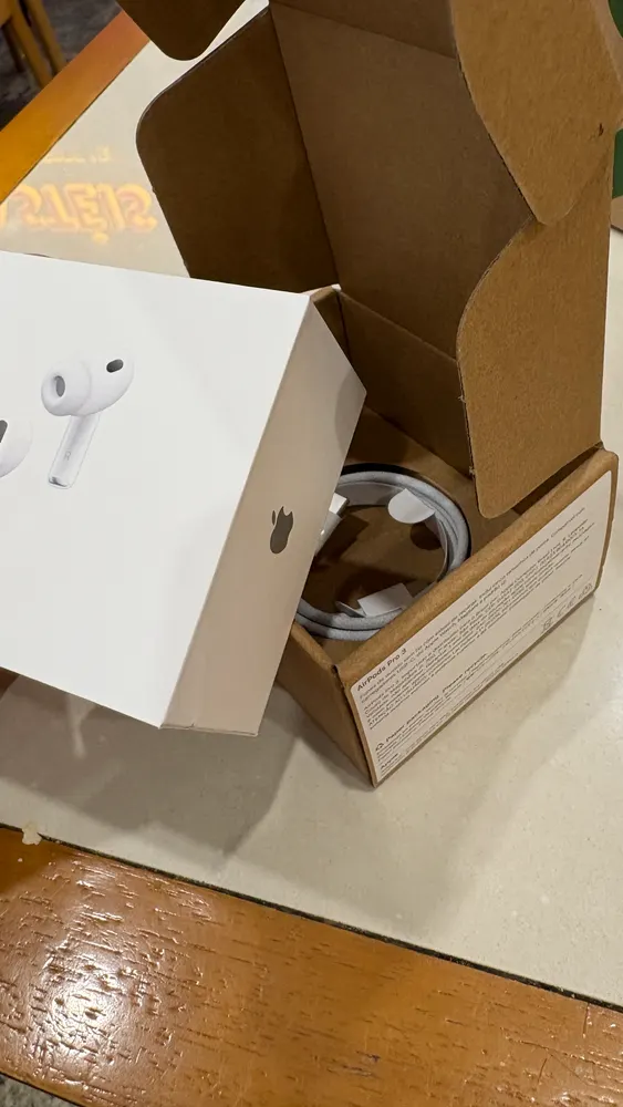 Caixa de fones AirPods Pro sendo tirada de uma caixa de papelão com cabo